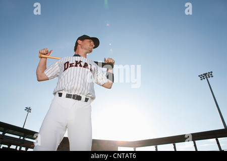 Baseball player holding bat across shoulders Stock Photo