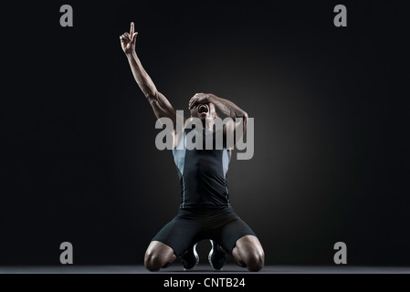 Male athlete shouting with finger pointing up Stock Photo