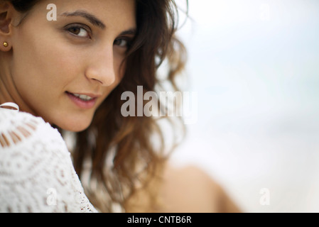 Young woman looking over shoulder, cropped