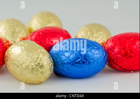 Chocolate Easter eggs in yellow,red and blue wrappings Stock Photo