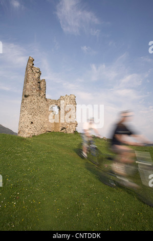 two mountain bikers passing Ardvreck Castle, United Kingdom, Scotland, Sutherland Stock Photo