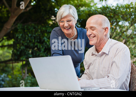 Older couple using laptop outdoors Stock Photo