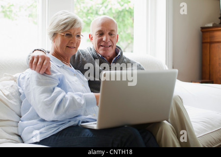 Smiling older couple using laptop Stock Photo