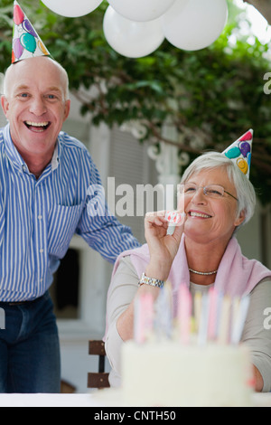 Older couple laughing at birthday party Stock Photo