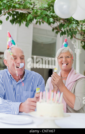 Older couple laughing at birthday party Stock Photo