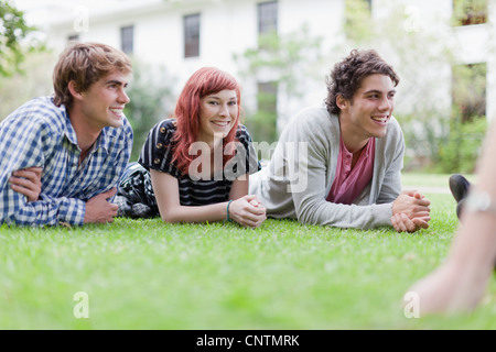 Students relaxing on grass on campus Stock Photo