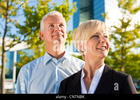 Business people standing in a park outdoors in front of a office building Stock Photo