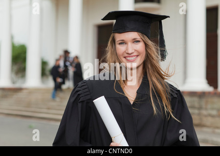 Graduate with her degree on campus Stock Photo
