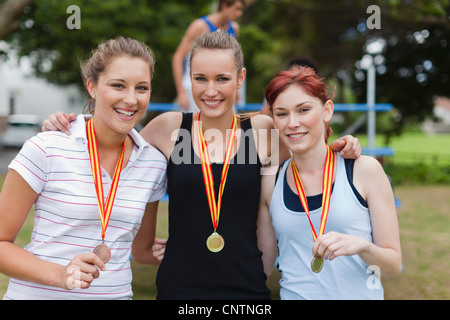 Women wearing medals in park Stock Photo