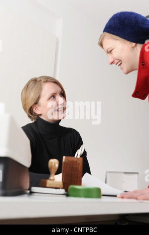Businesswomen talking at desk in office Stock Photo