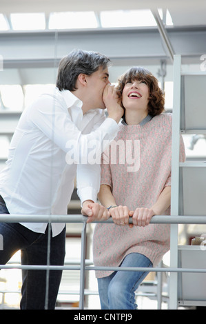 Business people whispering in office Stock Photo