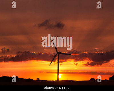 Wind turbine against sunset sky Stock Photo