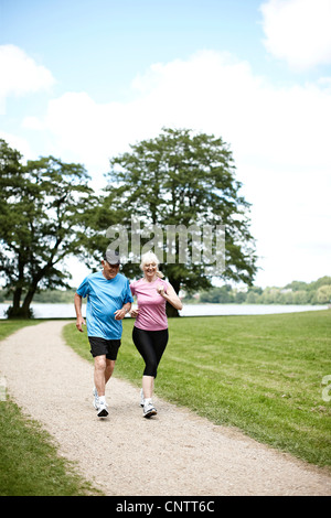 Older couple jogging together outdoors Stock Photo