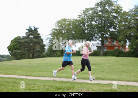 Older couple jogging together outdoors Stock Photo