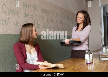 Woman talking to waitress in cafe Stock Photo