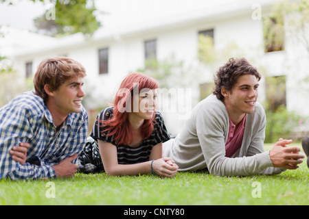 Students relaxing on grass on campus Stock Photo