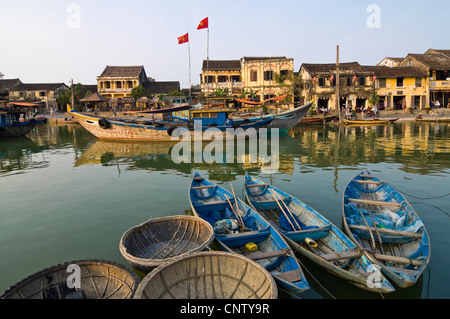 Horizontal view of traditional fishing boats moored alongside the Thu Bồn River estuary in the centre of Hoi An Old Town, Vietnam Stock Photo