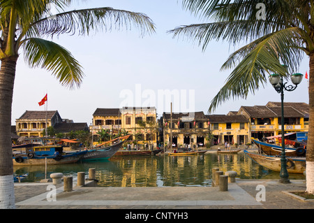 Horizontal view of boats on the Thu Bồn River estuary flowing through the centre of Hoi An Old Town, Vietnam. Stock Photo