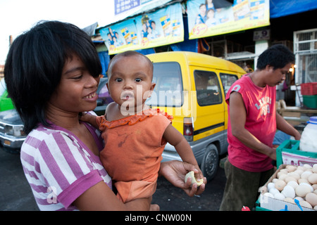 Woman with her baby, she is buying Balut, a fertilized duck embryo from a roadside vendor. Carbon Market, Cebu City, Philippines Stock Photo