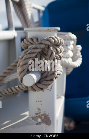 A mooring rope tied around the bitts of a small ship Stock Photo