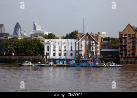 Metropolitan Police Service Marine Unit (MPU) and pontoon with moored police boats seen from Rotherhithe. Gherkin in background. Stock Photo