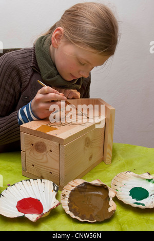 girl cleaning a birds' nest box Stock Photo