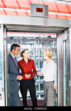 Business people riding elevator Stock Photo