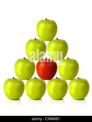 green apples on a pyramid shape with one red apple in the middle, be different Stock Photo