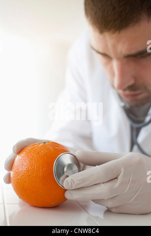 Scientist using stethoscope on orange Stock Photo