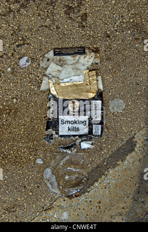 crushed empty packet of benson & hedges sovereign cigarettes on wet ground Stock Photo