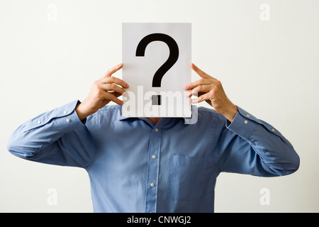 Man with question mark covering face. Stock Photo