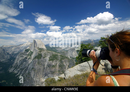 young female tourist picturing the Half Dome at the Yosemite National Park, USA, California, Sierra Nevada, Yosemite National Park Stock Photo