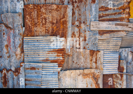 An abstract background image of rusty corrugated iron sheets overlapping to form a wall or fence. Stock Photo