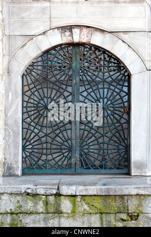 An istanbul mosque window in Turkey decorated with an intricate arabic style metal grating. Stock Photo