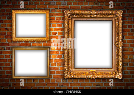 Old ornate golden frames hanging on a brick wall. Stock Photo