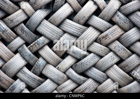 A background abstract image of a wall made entirely of rubber tyres. Stock Photo