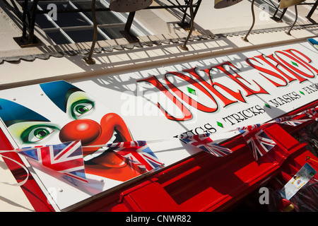 UK, England, Devon, Torquay, Vaughan Parade, Joke Shop sign with union jack flag bunting Stock Photo