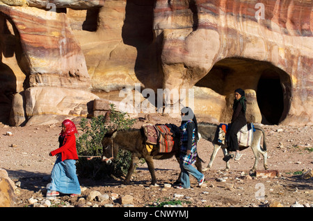 three bedouin women with two mount donkeys, Jordan, Petra Stock Photo