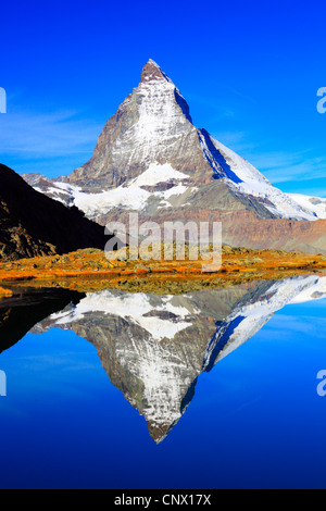 view from a mountain lake at the Matterhorn under clear blue sky, Switzerland, Valais Stock Photo