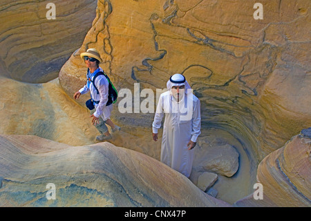 tourist and bedouin guide in a narrow canyon at Sinai desert, Egypt, Sinai Stock Photo