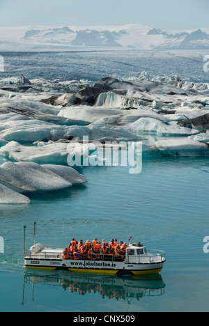 excursion boat on glacial lake Joekulsarlon full of melting ice in front of glacier Breidamerkurjoekull, Iceland Stock Photo