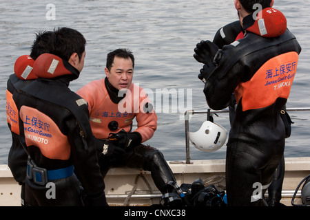 Japanese coast guard search underwater for the bodies of victims of the March2011 tsunami, in Kesennuma harbour, Tohoku, Japan. Stock Photo