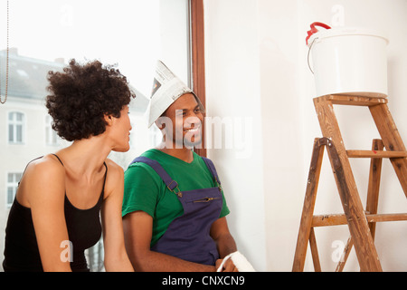 A couple taking a break from painting their apartment Stock Photo