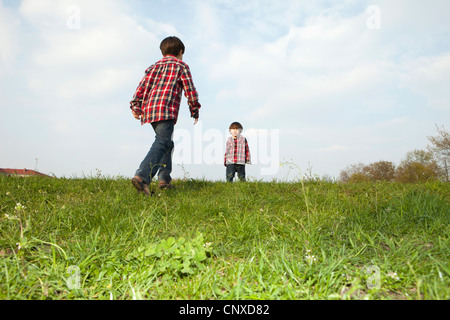 Two brothers in matching outfits outdoors Stock Photo