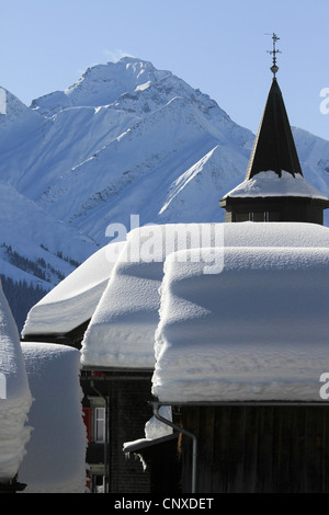 Snow-capped cabins and mountain range in background Stock Photo