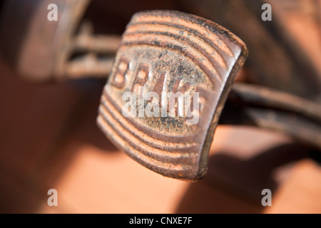 A worn, rusty pedal with BRAKE written on it in a land vehicle, close-up Stock Photo