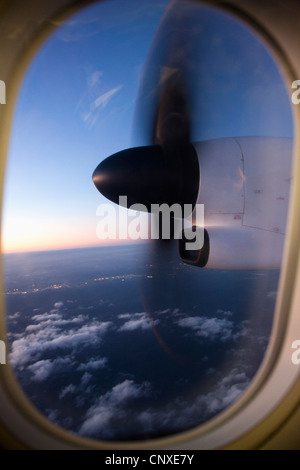 Moving airplane propeller seen through airplane window Stock Photo