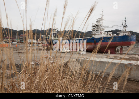 large fishing vessel sits stranded on land, after being carried inland from port by the March2011 tsunami, in Kesennuma, Japan. Stock Photo