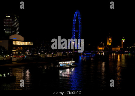 London's South Bank, The London Eye and Parliament by Night. Stock Photo