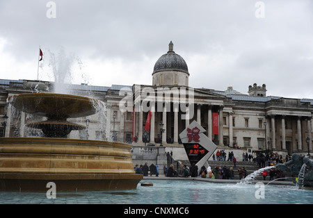 Tourists visiting Trafalgar Square on a wet April day Stock Photo